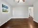 Bedroom with hardwood floors, neutral paint, window with view of trees, and open doorway to a bathroom at 233 Banberry Se Dr, Atlanta, GA 30315