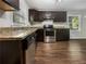 Kitchen features granite countertops, stainless steel appliances, and dark cabinetry, and wood-look flooring at 233 Banberry Se Dr, Atlanta, GA 30315