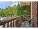 Cozy balcony featuring stone railings, a glass table, and views of the city and lush greenery at 77 Peachtree Ne Pl # 107, Atlanta, GA 30309