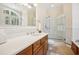 Bright bathroom featuring a double vanity with stone countertop and glass enclosed shower at 77 Peachtree Ne Pl # 107, Atlanta, GA 30309