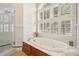 Bright bathroom featuring a soaking tub and a large window with white shutters at 77 Peachtree Ne Pl # 107, Atlanta, GA 30309