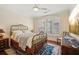 Cozy bedroom with a brass bed frame, hardwood floors, and a large window with shutters at 77 Peachtree Ne Pl # 107, Atlanta, GA 30309