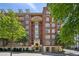 Beautiful brick building with ornate balconies and lush green trees surrounding the exterior at 77 Peachtree Ne Pl # 107, Atlanta, GA 30309