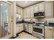View of the kitchen featuring stainless steel appliances, black countertops, and beige tiled floors at 77 Peachtree Ne Pl # 107, Atlanta, GA 30309