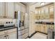 Bright kitchen with stainless steel refrigerator, glass cabinets, black counters, and beige tiled floor at 77 Peachtree Ne Pl # 107, Atlanta, GA 30309