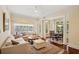 Bright living room with large windows, white sectional sofa, area rug, and adjacent dining area at 77 Peachtree Ne Pl # 107, Atlanta, GA 30309