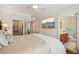 Comfortable main bedroom featuring walk-in closet, adjacent bathroom, and mounted television at 77 Peachtree Ne Pl # 107, Atlanta, GA 30309