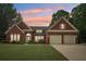 Brick home with a two-car garage, lush landscaping, and a manicured lawn at 1675 Bookhout Dr, Cumming, GA 30041