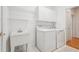 Functional laundry room with a utility sink, overhead storage, and modern washer and dryer for efficient laundry tasks at 1675 Bookhout Dr, Cumming, GA 30041