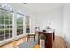 Bright home office featuring hardwood floors, a desk, and large windows offering ample natural light and neighborhood views at 1675 Bookhout Dr, Cumming, GA 30041