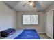 Comfortable bedroom with blue blanket, fan and natural light from the window at 1824 Guardian Way, Lawrenceville, GA 30043