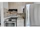 Modern kitchen with stainless steel stove and refrigerator, light countertops and brick backsplash at 1824 Guardian Way, Lawrenceville, GA 30043
