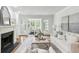 A living room with a fireplace and French doors that open to a bright sunroom at 3794 Ashford Lake Ne Ct, Brookhaven, GA 30319