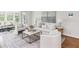 Living room with modern decor, white sofa and chairs, and natural light at 3794 Ashford Lake Ne Ct, Brookhaven, GA 30319