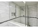 Beautiful glass enclosed shower with white tile, ledge and accent mosaic at 3794 Ashford Lake Ne Ct, Brookhaven, GA 30319
