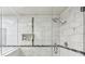 Beautiful glass enclosed shower with white tile and accent mosaic at 3794 Ashford Lake Ne Ct, Brookhaven, GA 30319
