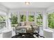 Cozy sun room with large windows, natural light, and comfortable seating and plants for a relaxing atmosphere at 3794 Ashford Lake Ne Ct, Brookhaven, GA 30319