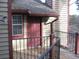 Red door with brass accents on front porch with painted wood and black metal railings at 412 Hawkstone Way, Alpharetta, GA 30022