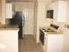 Efficient kitchen with tan countertops, white cabinets, tile floors and modern appliances at 412 Hawkstone Way, Alpharetta, GA 30022