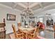 Bright dining room featuring hardwood floors, wainscoting, and a coffered ceiling with modern chandelier at 4215 Cordova Ln, Cumming, GA 30028