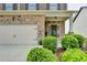 Inviting front entrance with stone accents, well-manicured bushes, and a convenient attached garage at 4215 Cordova Ln, Cumming, GA 30028