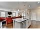 Open-concept kitchen with granite island flows into living area with fireplace, perfect for entertaining at 4215 Cordova Ln, Cumming, GA 30028
