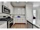 Modern kitchen featuring stainless steel appliances, granite countertops, and white cabinetry at 4215 Cordova Ln, Cumming, GA 30028