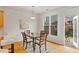 Bright dining area featuring hardwood floors, glass table, and backyard access through the French doors at 6275 Glen Oaks Ln, Atlanta, GA 30328