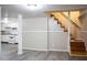 Renovated basement with kitchenette area, grey vinyl flooring, stairs to the upper level, and freshly painted walls at 6470 Sherwood Trl, Austell, GA 30168