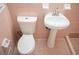 Bathroom featuring a pedestal sink and a classic toilet with pink tiles at 6470 Sherwood Trl, Austell, GA 30168