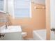 Bathroom with peach tile, window, and combination shower and bathtub at 6470 Sherwood Trl, Austell, GA 30168