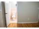 View of an adjacent bathroom with pink tile from a bedroom with hardwood floors at 6470 Sherwood Trl, Austell, GA 30168