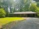 A quaint brick home with an attached carport, lush lawn and shady mature trees at 6470 Sherwood Trl, Austell, GA 30168
