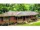 Brick ranch home with covered porch, black shutters, and mature landscaping at 6470 Sherwood Trl, Austell, GA 30168