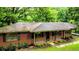 Brick ranch-style home featuring black shutters, a covered porch, and well-maintained landscaping for a cozy curb appeal at 6470 Sherwood Trl, Austell, GA 30168