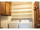 Bright laundry room with washer, dryer, and shelving at 6470 Sherwood Trl, Austell, GA 30168