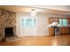 Spacious living area featuring hardwood floors, a stone fireplace, and kitchen access creating a connected space at 6470 Sherwood Trl, Austell, GA 30168