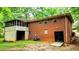 Brick home's rear exterior with screened-in porch, yard access, and mature trees offering privacy and shade at 6470 Sherwood Trl, Austell, GA 30168