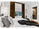 Bright bedroom features a large window with curtains, en suite bathroom, hardwood floors, decorative mirrors, and patterned rug at 2498 Perry Nw Blvd, Atlanta, GA 30318