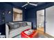 Stylish blue living room with daybed, ottoman, and powder room entrance at 2498 Perry Nw Blvd, Atlanta, GA 30318
