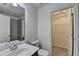 Bright bathroom with a walk-in closet, toilet, sink, and vanity with modern chrome fixtures at 2725 Monet Dr, Cumming, GA 30041