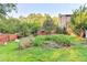 View of lush backyard featuring a garden, trees, and a wooden fence at 4364 Saddlecreek Ct, Auburn, GA 30011