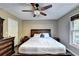 This bedroom features hardwood floors, ceiling fan, large bed, and a window at 4364 Saddlecreek Ct, Auburn, GA 30011