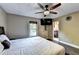 This bedroom features hardwood floors, ceiling fan, large bed, and a door to the ensuite bathroom at 4364 Saddlecreek Ct, Auburn, GA 30011
