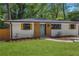Charming white brick home with modern wood accents, green lawn, and lush landscaping at 2392 Jefferson Ter, Atlanta, GA 30344