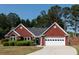 Charming red brick home with manicured landscaping, an attached garage, and a classic architectural design at 310 Morning Glen Dr, Suwanee, GA 30024