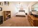 Bright main bedroom featuring neutral carpeting, ceiling fan, vaulted ceiling, and a comfortable bed at 310 Morning Glen Dr, Suwanee, GA 30024