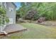 Spacious backyard with a brick patio, tiered landscaping, and mature trees at 3958 Windgrove Xing, Suwanee, GA 30024