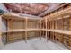 Unfinished basement area with built-in wooden shelving for storage and organization at 3958 Windgrove Xing, Suwanee, GA 30024