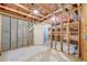 Unfinished basement features concrete walls, exposed ceiling, door, and shelving being constructed at 3958 Windgrove Xing, Suwanee, GA 30024